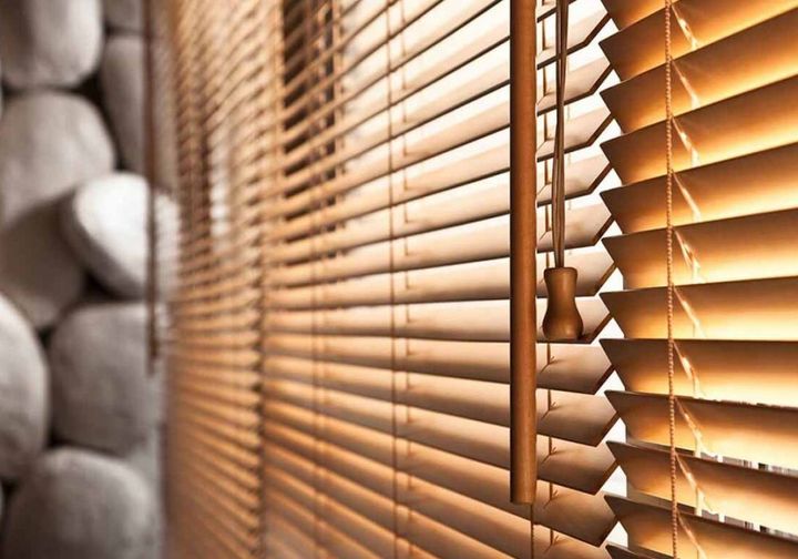 Raking light across the grain and edges of wooden blind slats